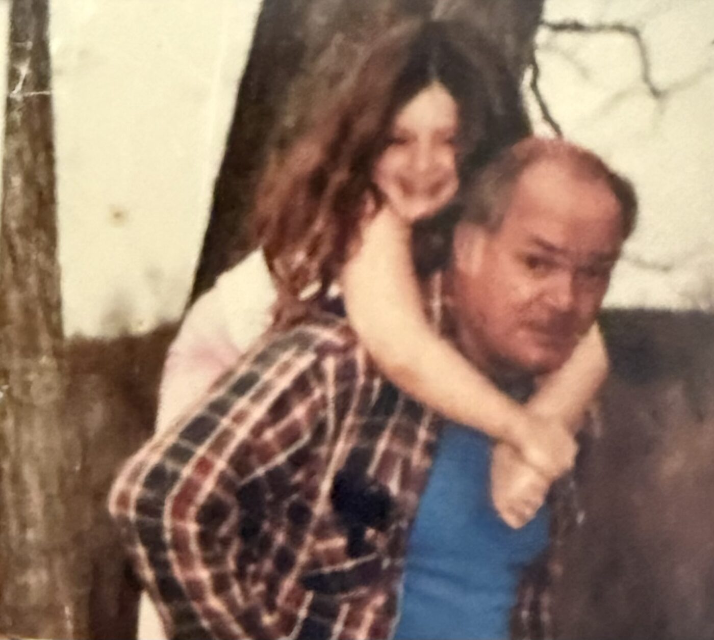 Karlee as a little girl riding on her grandfather's back