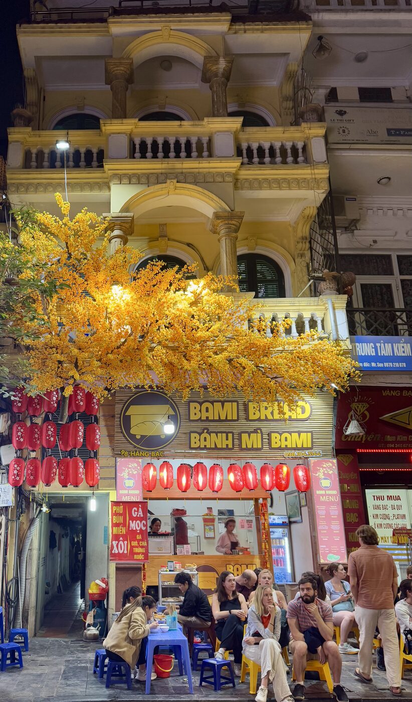 The bánh mì shop in Hanoi under a yellow tree and red lanterns