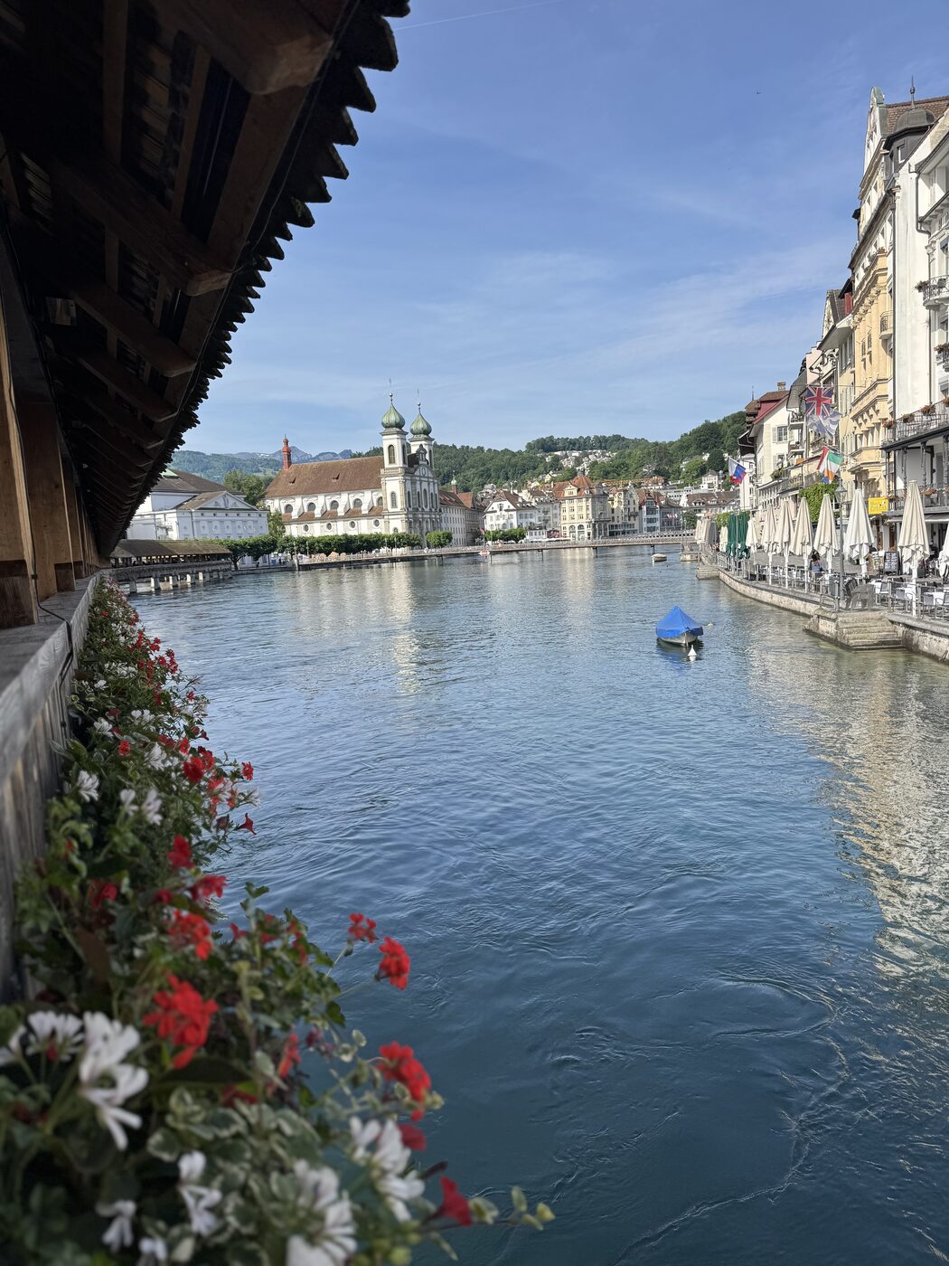 Geraniums along the Chapel Bridge in Lucerne, the river and old town behind
