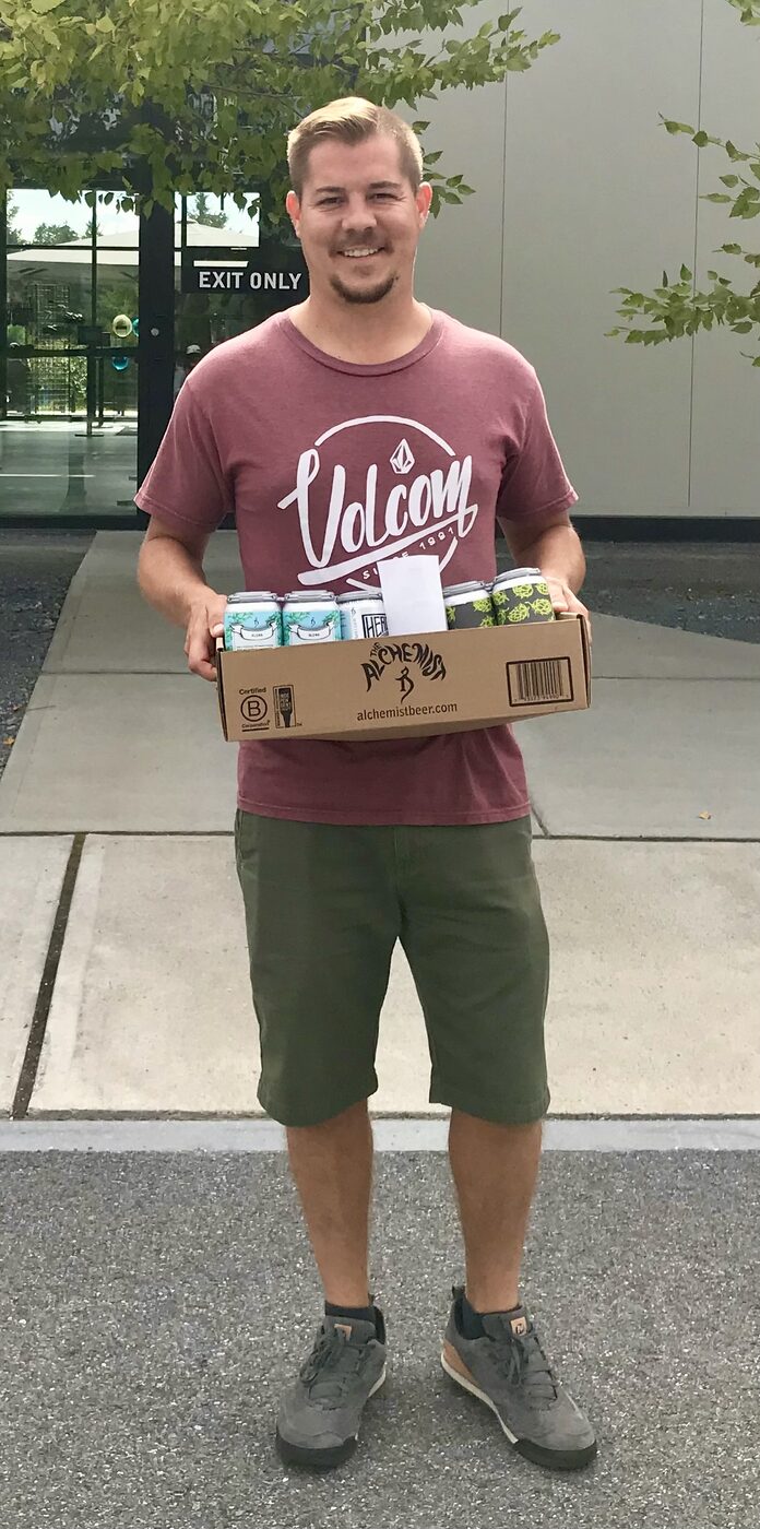 Jesse holding a case of beer outside The Alchemist