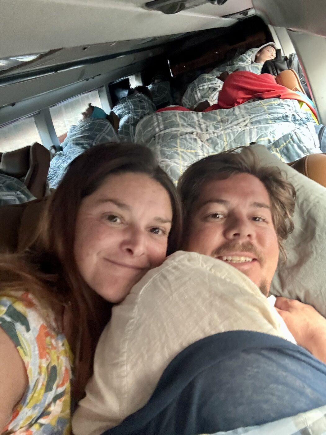 Karlee and Jesse tucked into a sleeper bus bunk in northern Laos