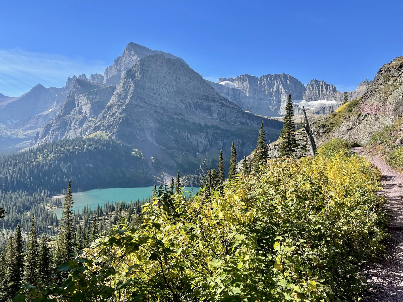 The Grinnell Glacier trail in Glacier National Park, fall color along the path and Grinnell Lake far below