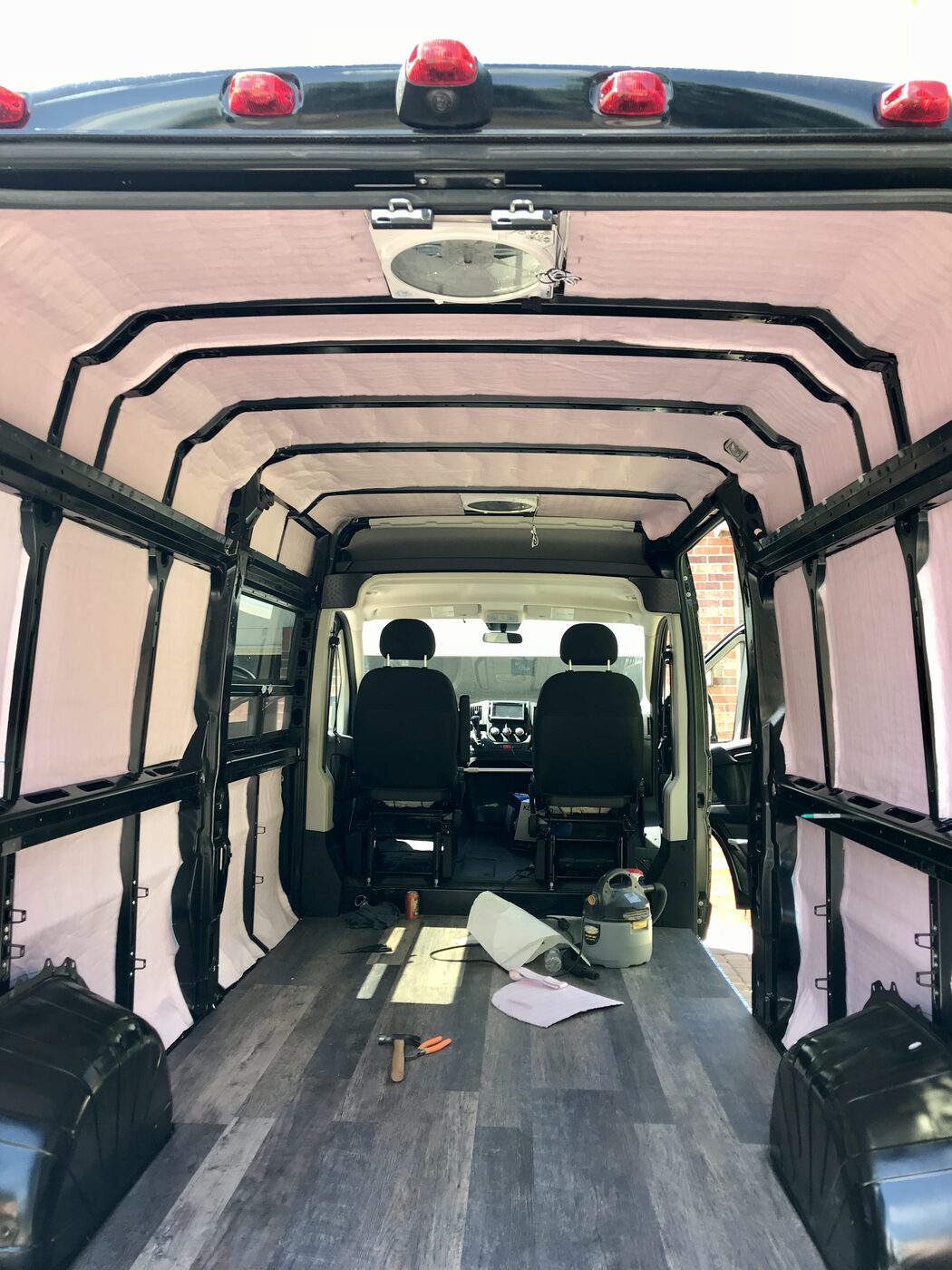 The empty van mid-build in 2018: floor down, pink insulation, bare ribs overhead