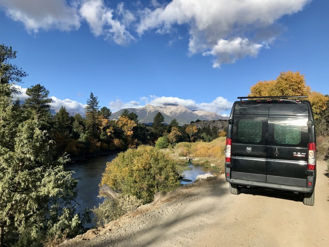 The van on a mountain road surrounded by golden aspens