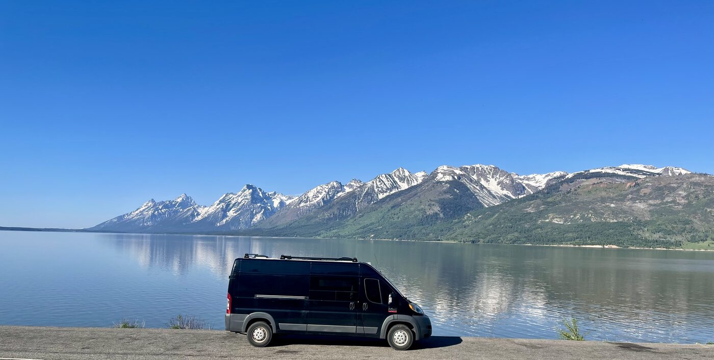 The van parked on the shore of Jackson Lake below the Tetons
