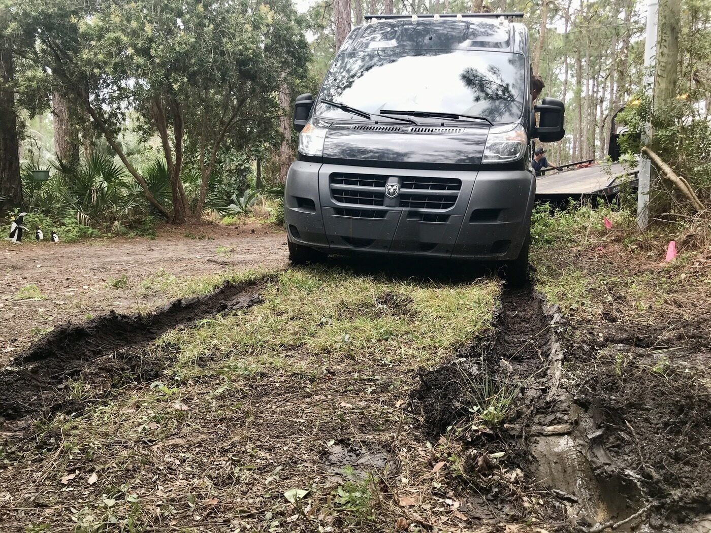 The van's front wheels sunk into muddy ruts